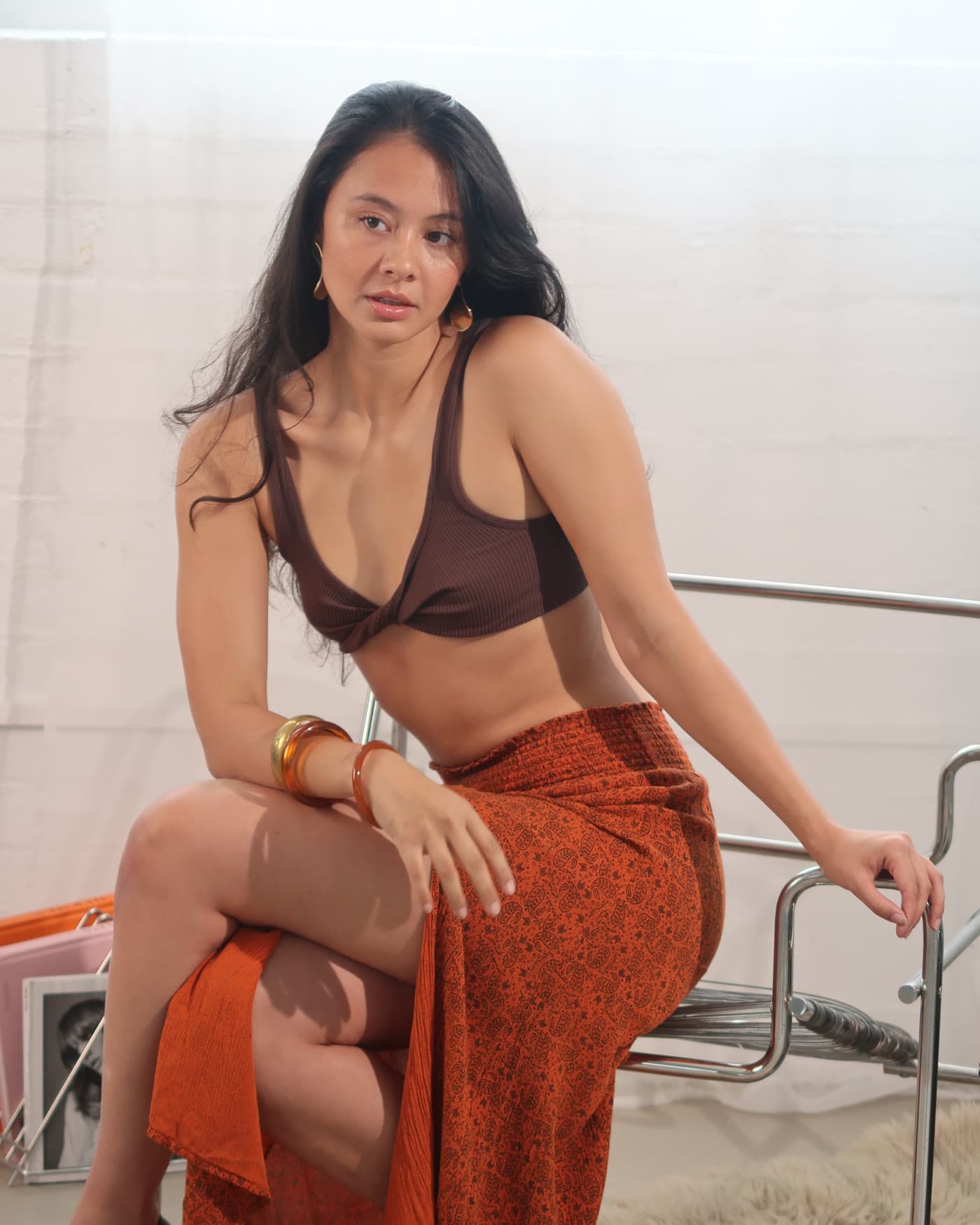 Finished frame, model seated in an orange skirt