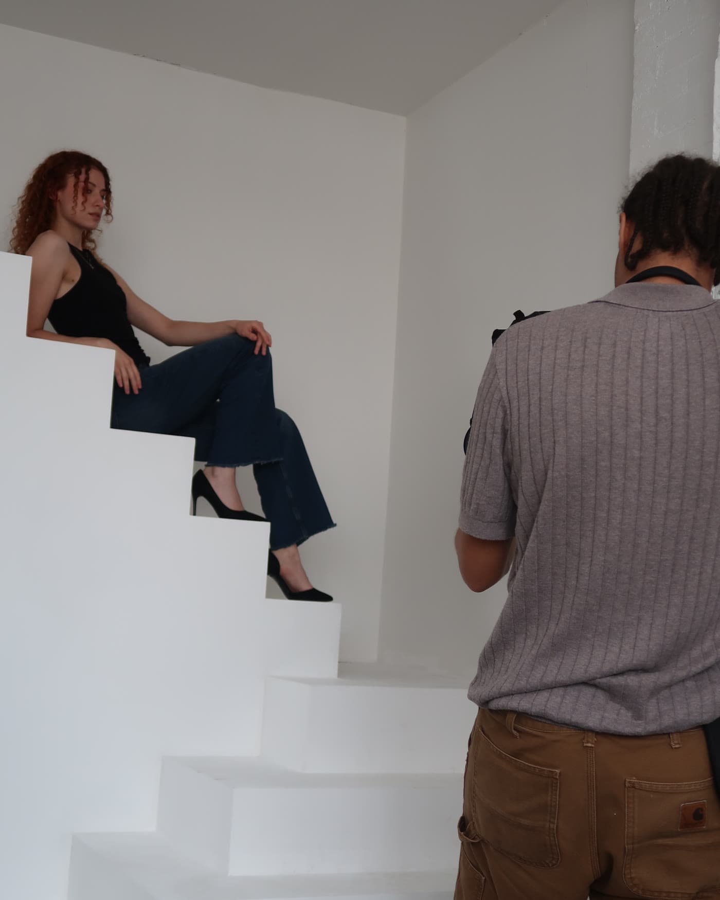 A model directed on the stairs while a photographer works