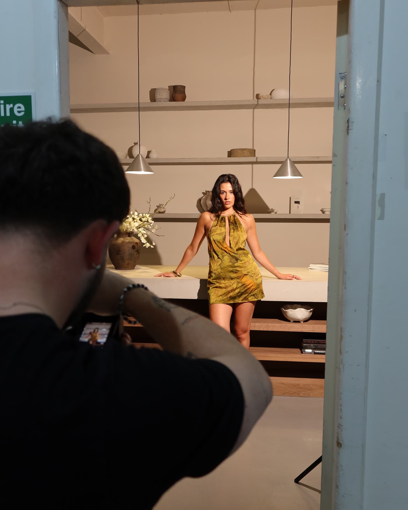 Model in a yellow dress being photographed in a doorway