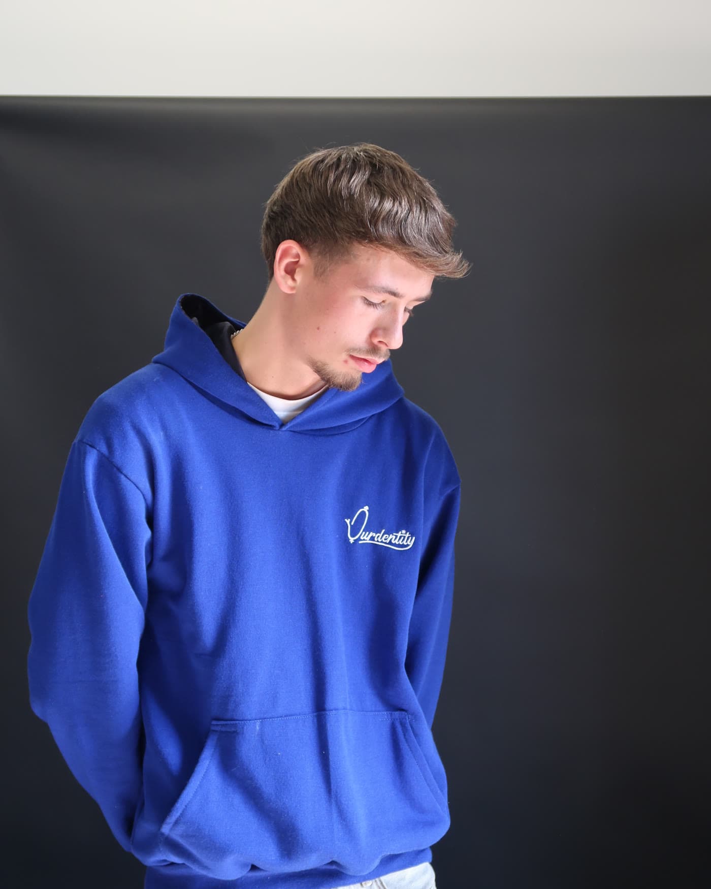 Campaign frame, model in a cobalt hoodie