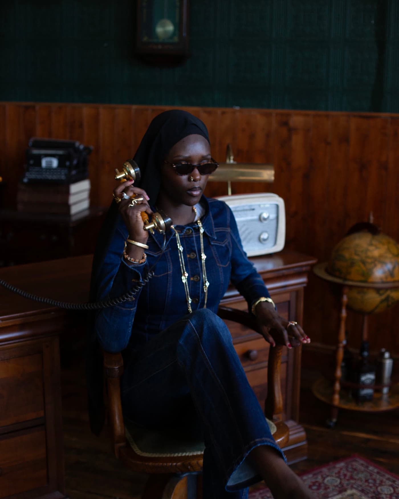 Seated denim portrait with a brass telephone